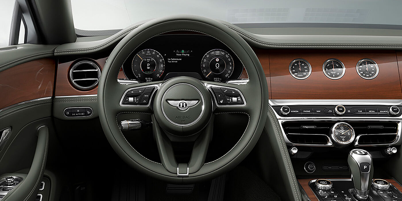 Bentley Singapore New Bentley Flying Spur sedan front cabin in Cumbrian Green hide and Crown Cut walnut veneer showing steering wheel and Rotating Display with three clocks on face