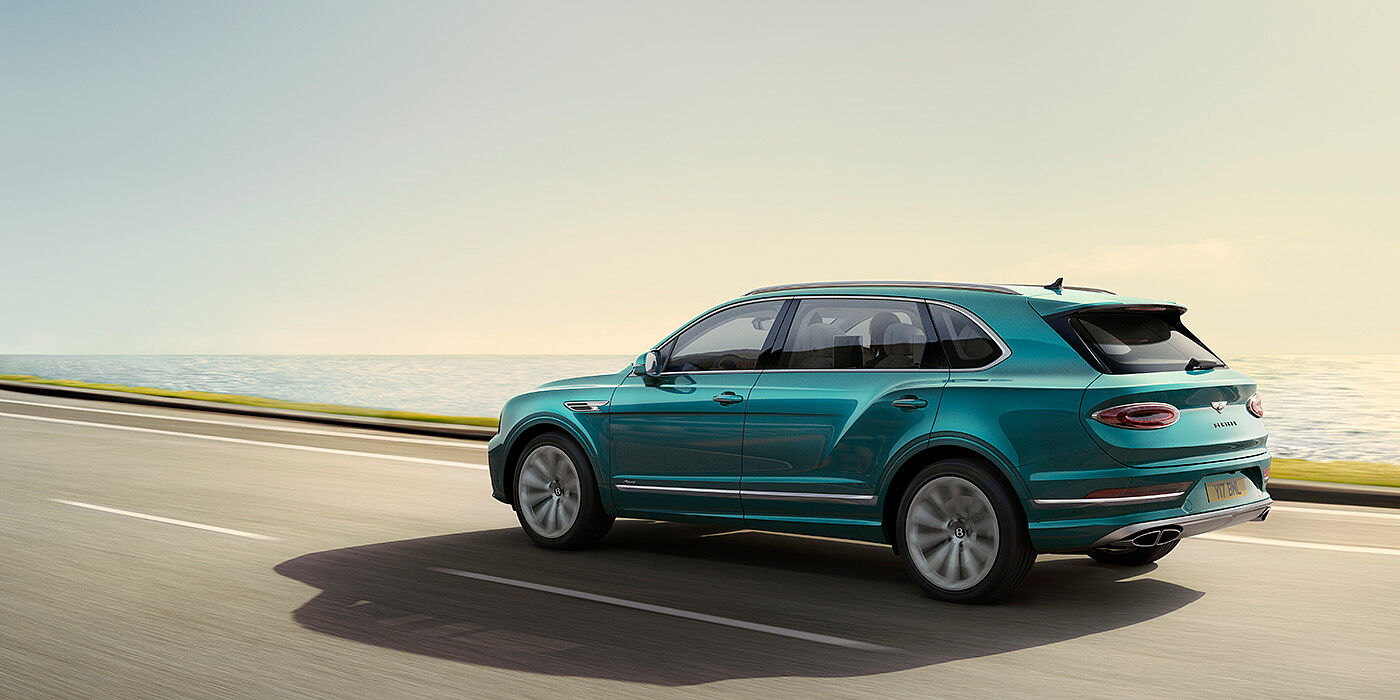 Bentley Singapore Rear view of a Topaz blue Bentley Bentayga EWB Azure, cruising along a sea side road.