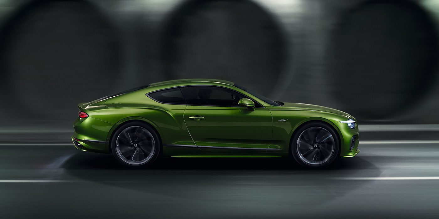 Bentley Singapore Bentley Continental GT coupe in Tourmaline Green paint driving in profile on a dark road