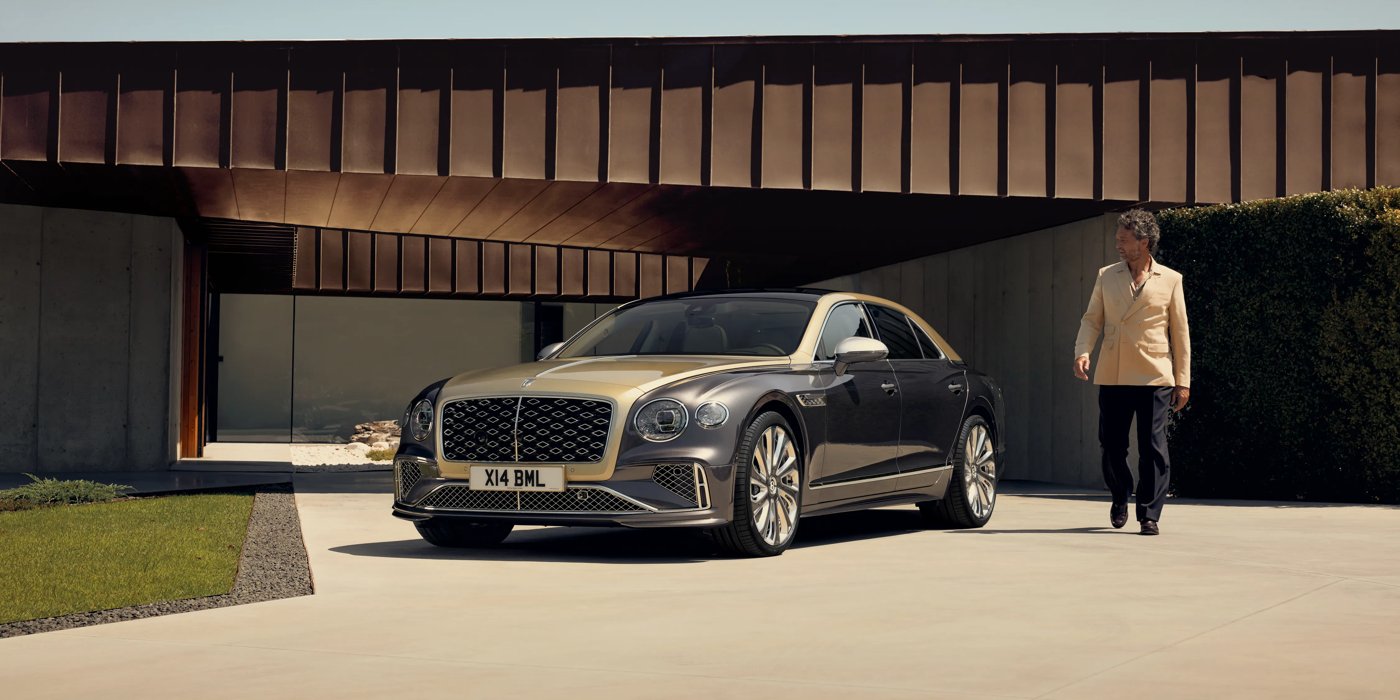 Bentley Singapore Bentley New Flying Spur Mulliner V8 hybrid sedan front three quarters in Rose Gold over Magnetic paint, parked near modern home