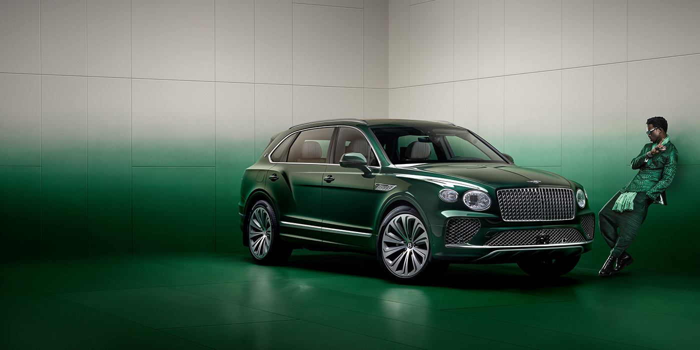 Bentley Singapore Wisdom K leans against wall next to Bentley Bentayga Extended Wheelbase Atelier Edition SUV in Light Emerald green paint
