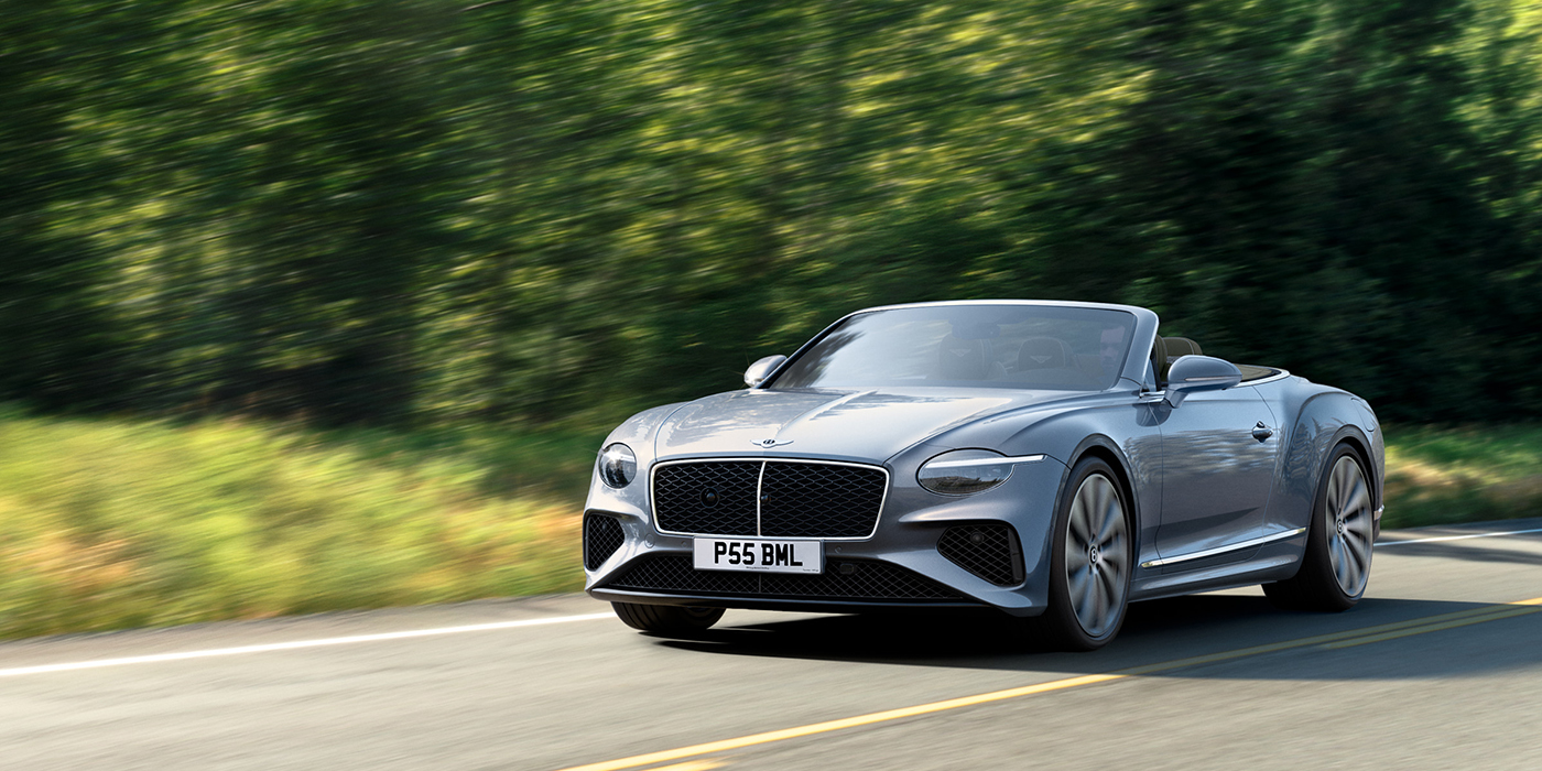 Bentley Singapore New Bentley Continental GTC convertible front view in Silverlake paint with 22 inch ten spoke wheels, driving dynamically on a country road