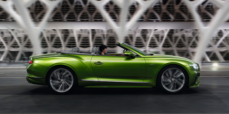 Bentley Singapore Bentley Continental GTC Speed convertible side profile in Tourmaline Green paint driving dynamically on a bridge at night