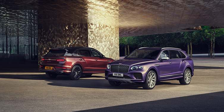 Bentley Singapore A duo of Bentley Bentayga Extended Wheelbase Mulliner SUVs parked in a city environment, with Tanzanite Purple and Cricket Ball red exterior paint